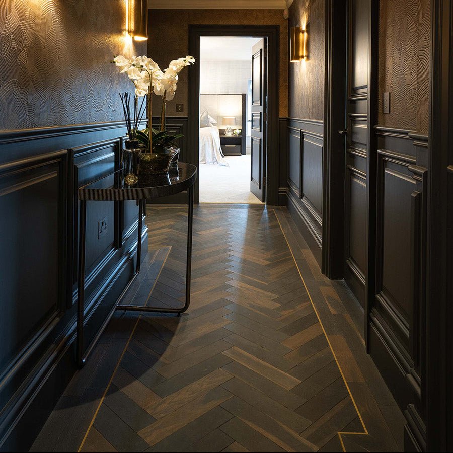 Dark wood herringbone floor with gold inlay lines in goodrich charred oak for elegant interior flooring
