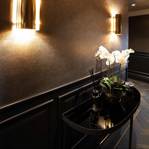 Black curved console table with a glossy finish and gold-trimmed legs from the goodrich charred oak collection