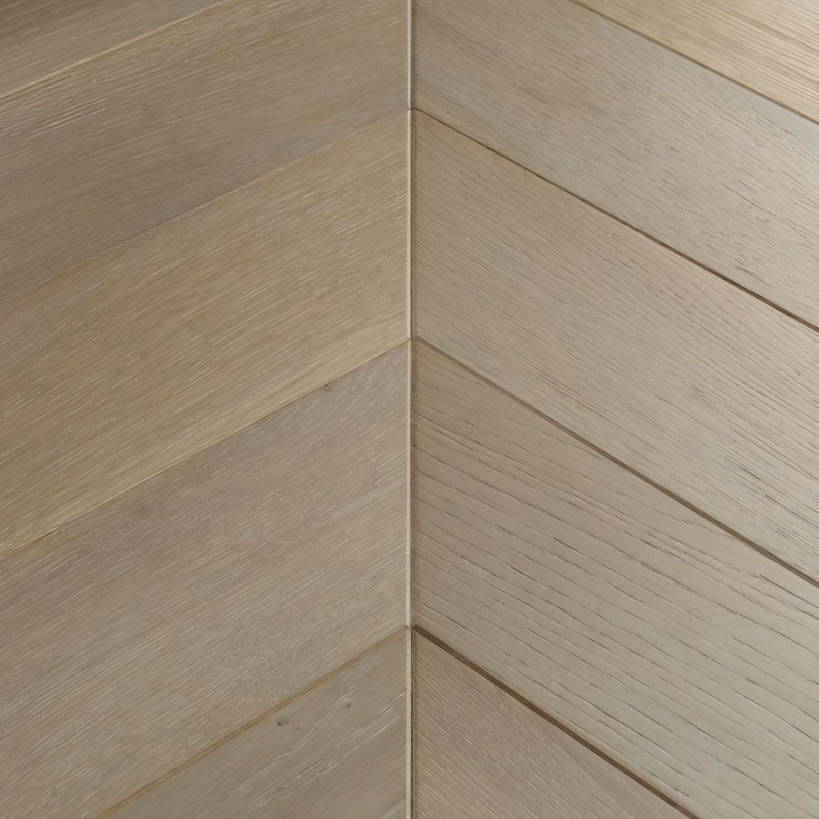 Light beige hardwood flooring with subtle wood grain in a herringbone layout goodrich feather oak chevron