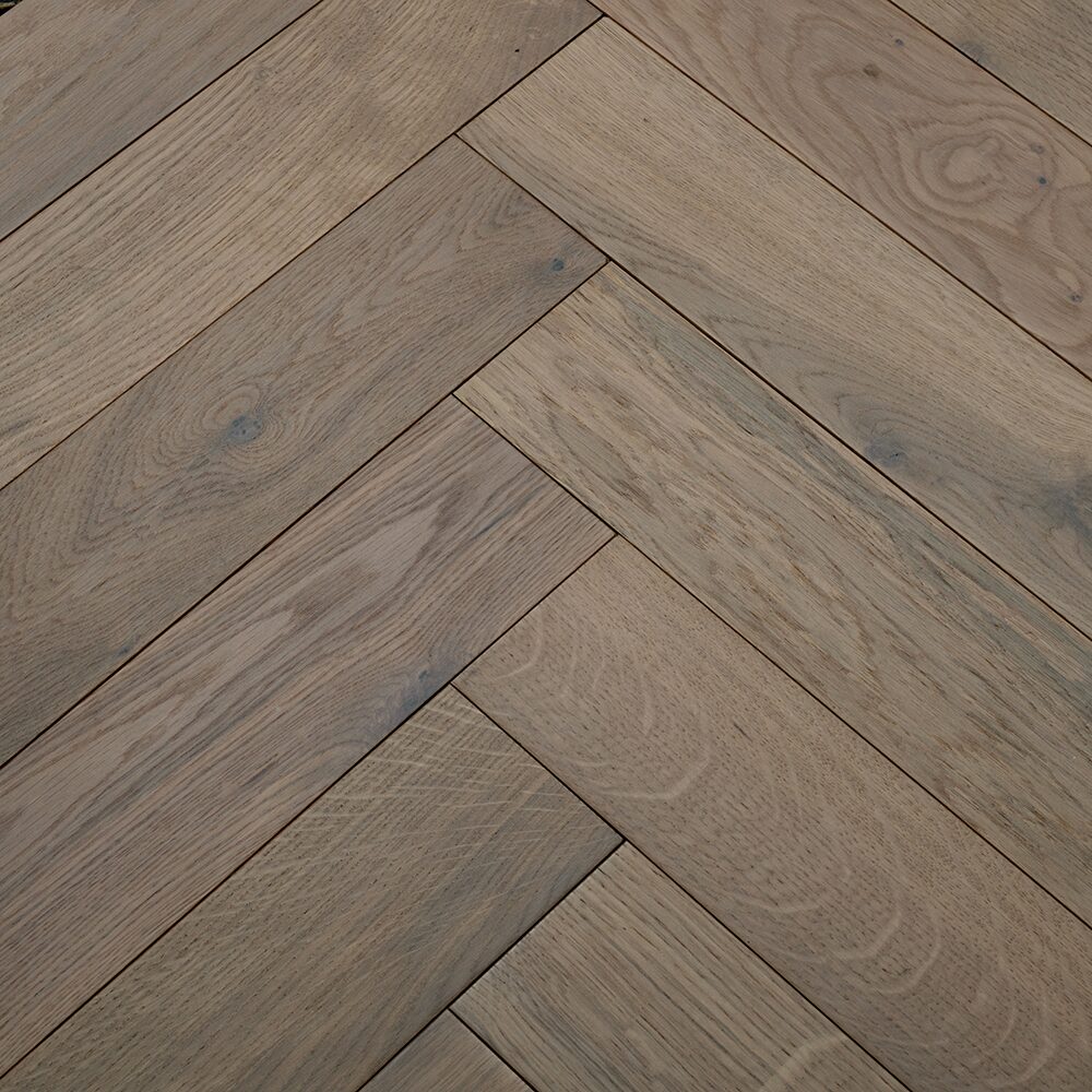 Grayish brown goodrich white oiled oak hardwood planks arranged in a herringbone pattern for flooring use