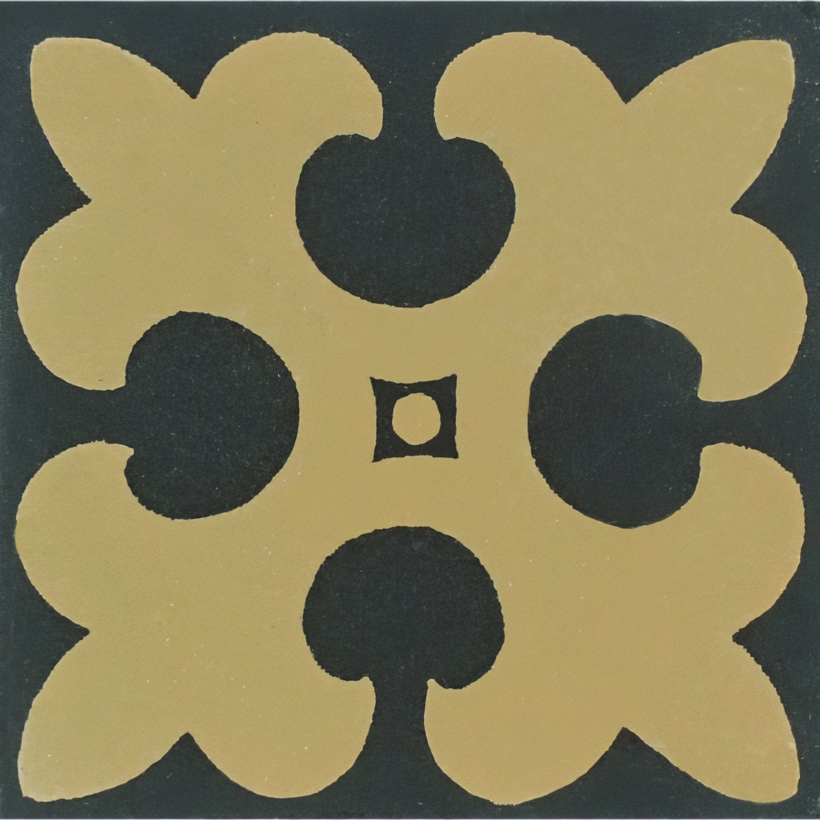 A square ceramic tile in gordon buff on black with a symmetrical gold and black quatrefoil design