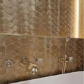 Gravity Aluminium Trace Gold Mosaic gold chevron aluminium mosaic with a brass bathtub tap and handheld shower