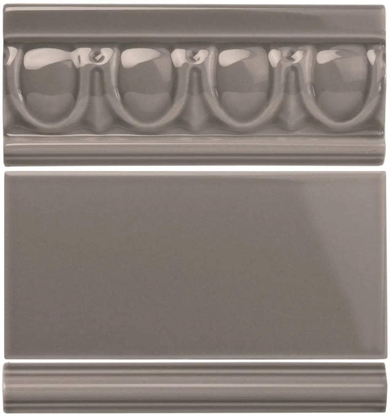 Gray ceramic tile with a decorative molded border featuring repeating oval and arch motifs.