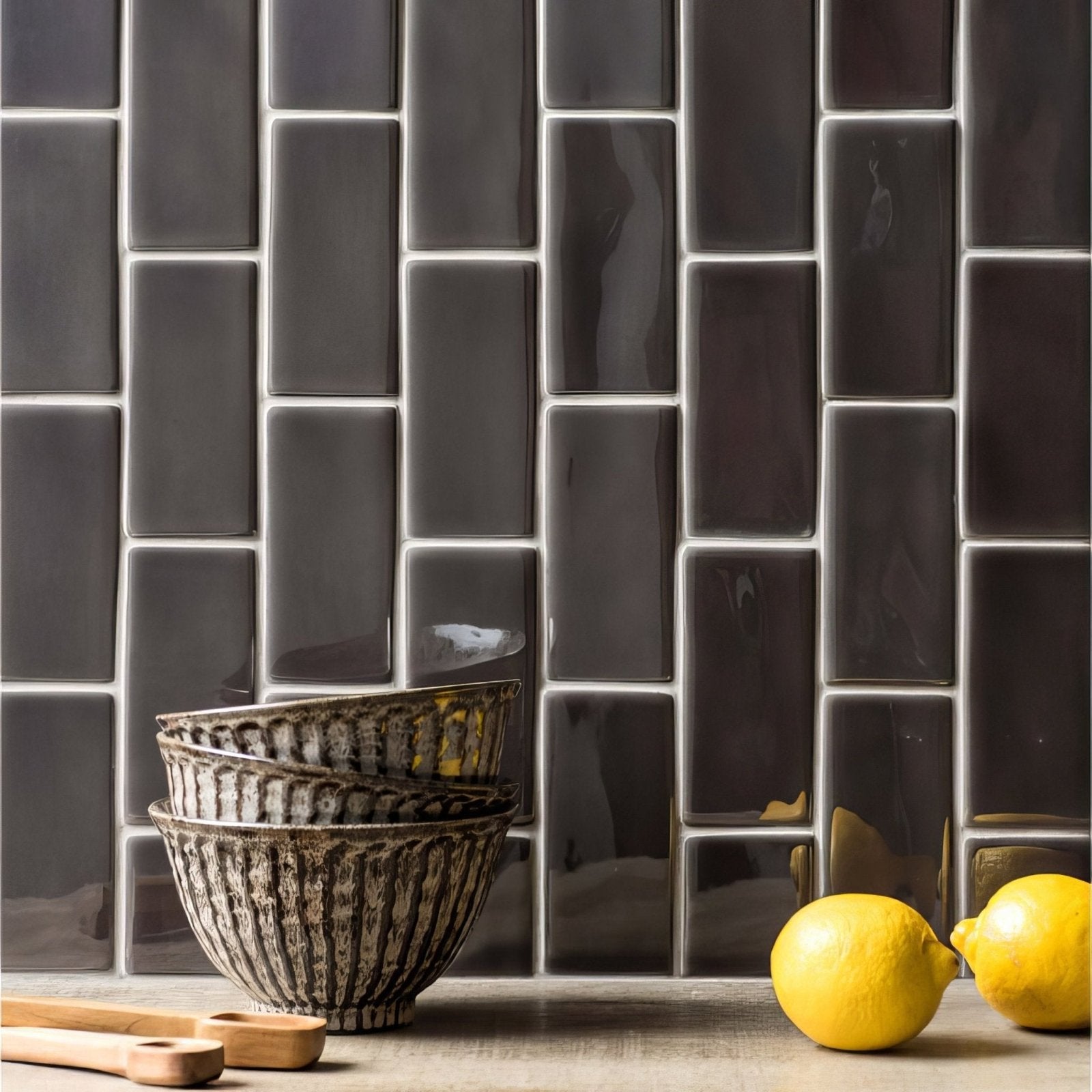 Stacked grey half tile ceramic bowls with textured ribbed surface and earthy tones on a countertop