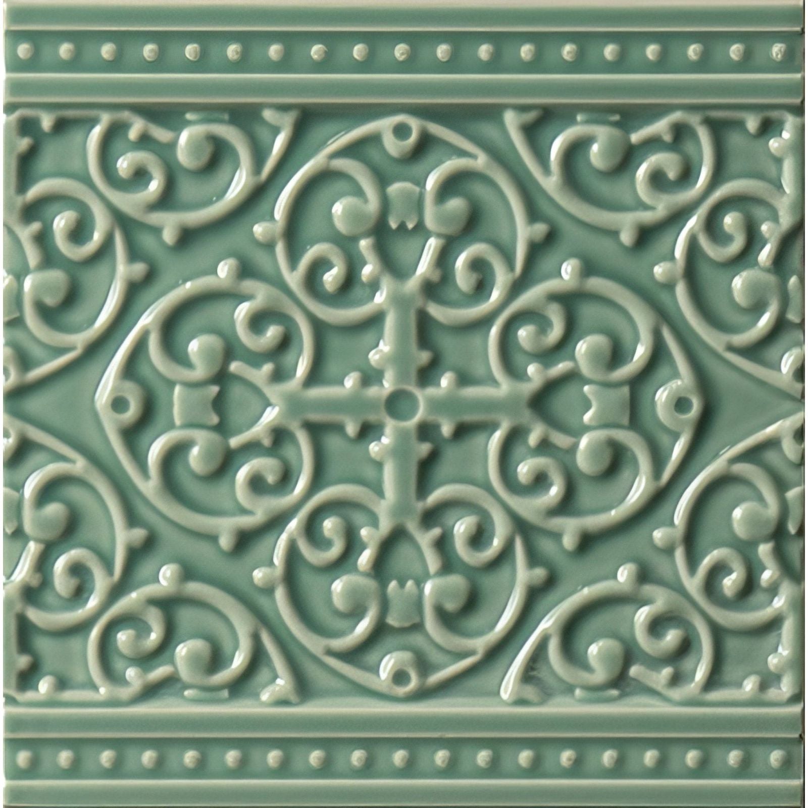 A decorative teal ceramic tile from Grosvenor on Jade Breeze with raised swirling motifs and a central cross design