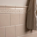 Beige ceramic hadleigh field tile border with ornate raised decorative molding for elegant wall accents