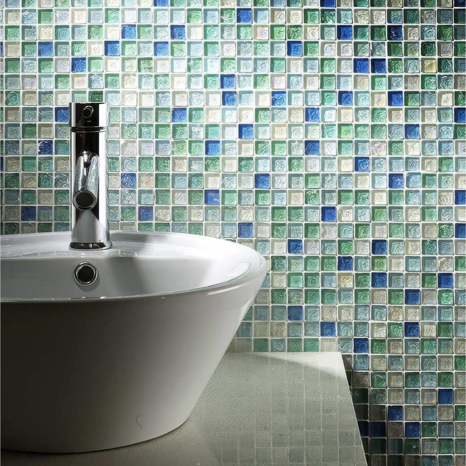 Hammered Pearl Aqua Glass Mosaic blue, teal and cream glass mosaic behind a white sink with a chrome tap