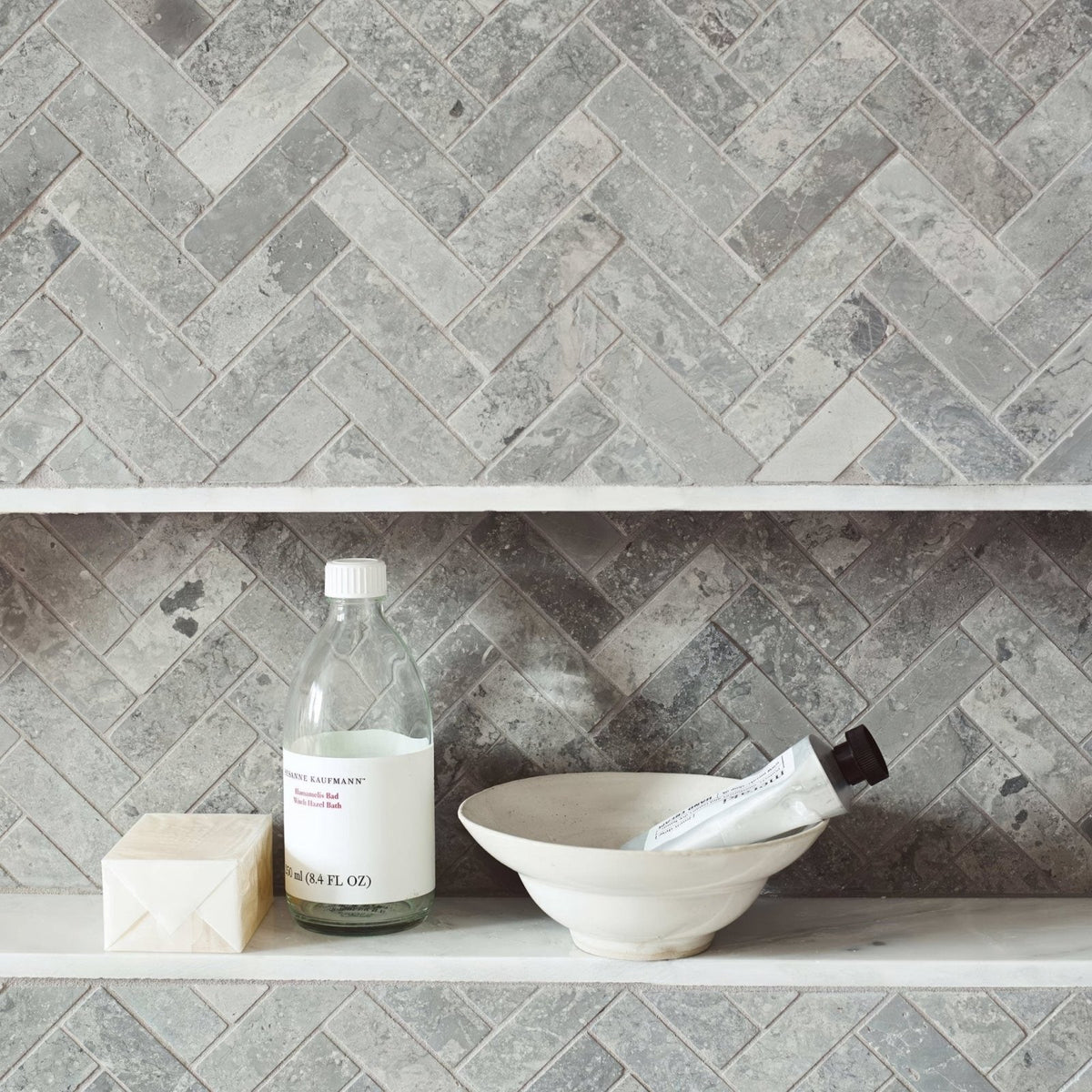 Hampton Bays Herringbone Mosaic grey stone herringbone mosaic with a clear glass bottle