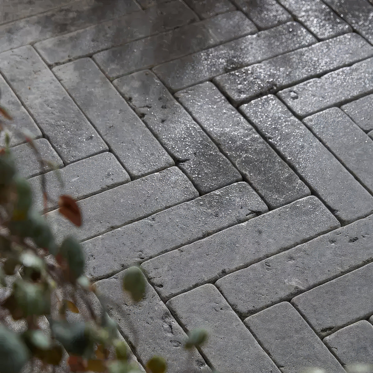 Hazlebury limestone tumbled and etched klinkers gray rectangular pavers arranged in a wet herringbone pattern