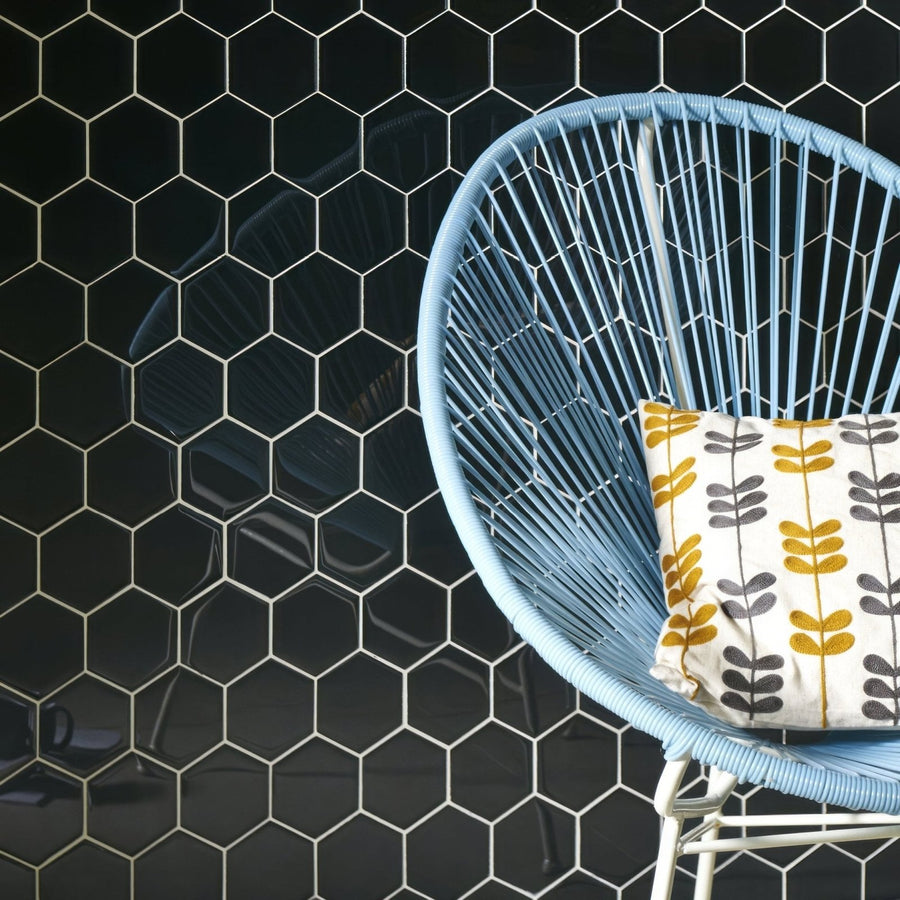 Hera Metallic Hexagon Mosaics black hexagon glass mosaic with a light blue wicker chair