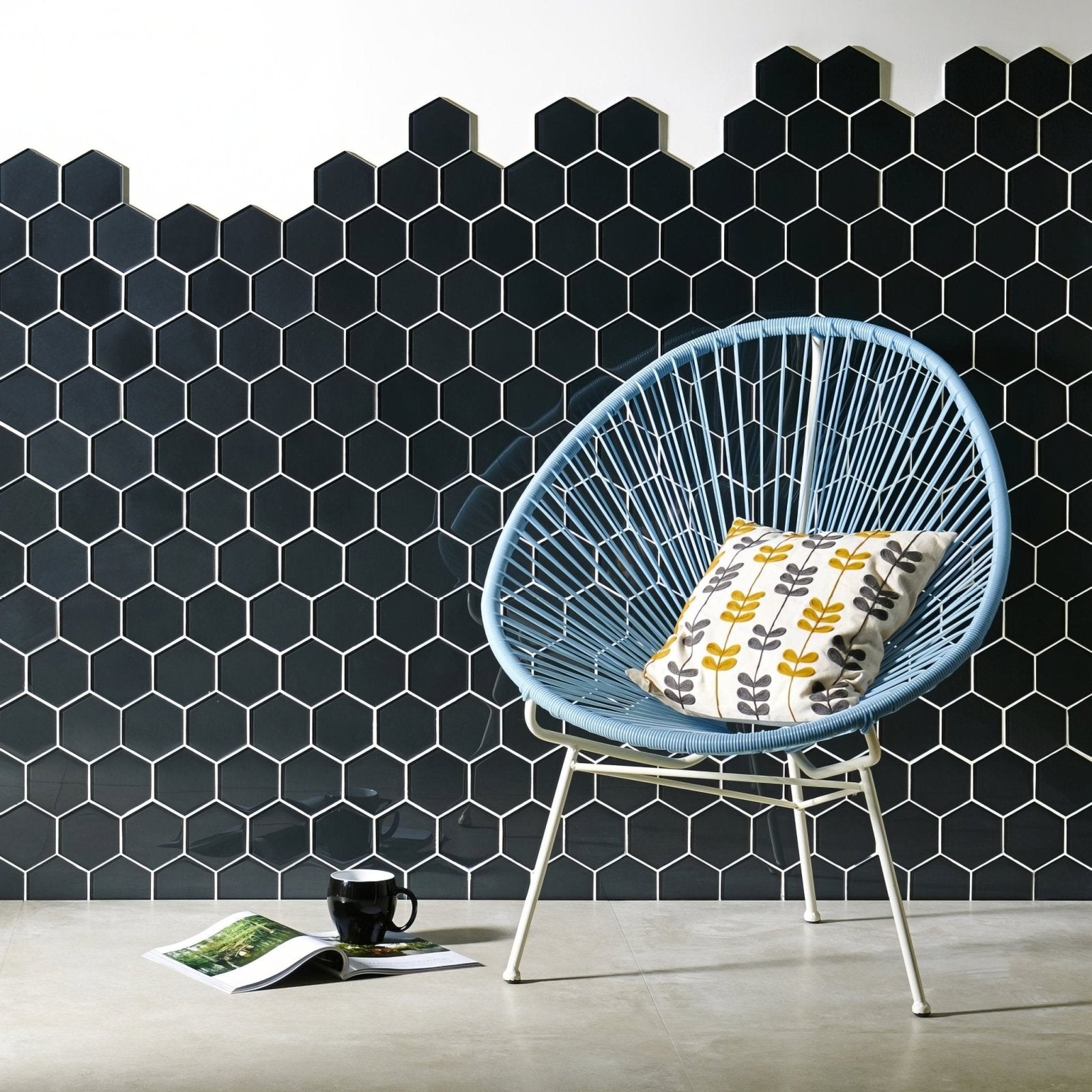 Hera Metallic Hexagon Mosaics black hexagon glass mosaic with a light blue woven chair