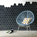 Hera Metallic Hexagon Mosaics black hexagon glass mosaic with a light blue woven chair