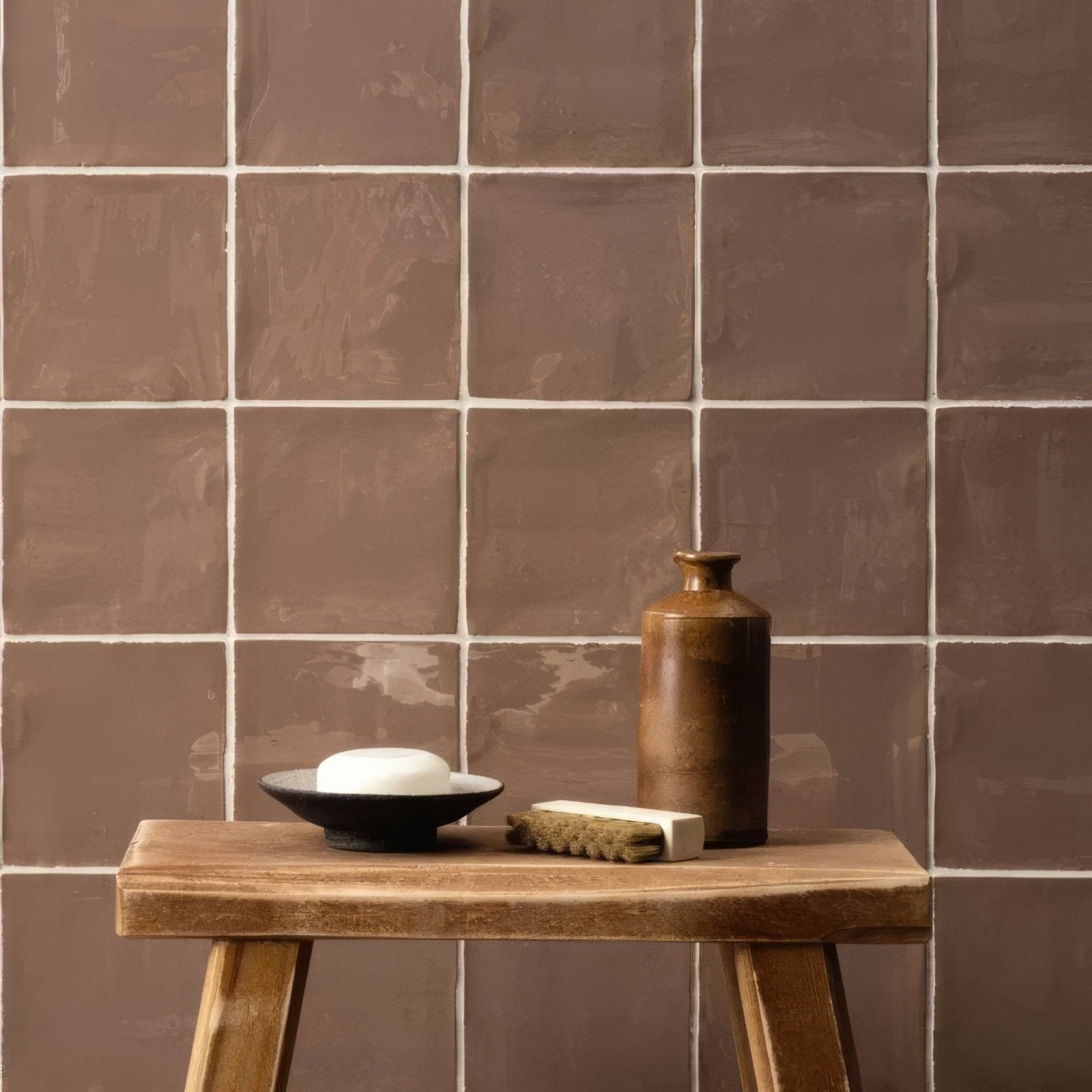 A matte brown ceramic hessian field tile vase with a narrow neck sits on a rustic wooden stool