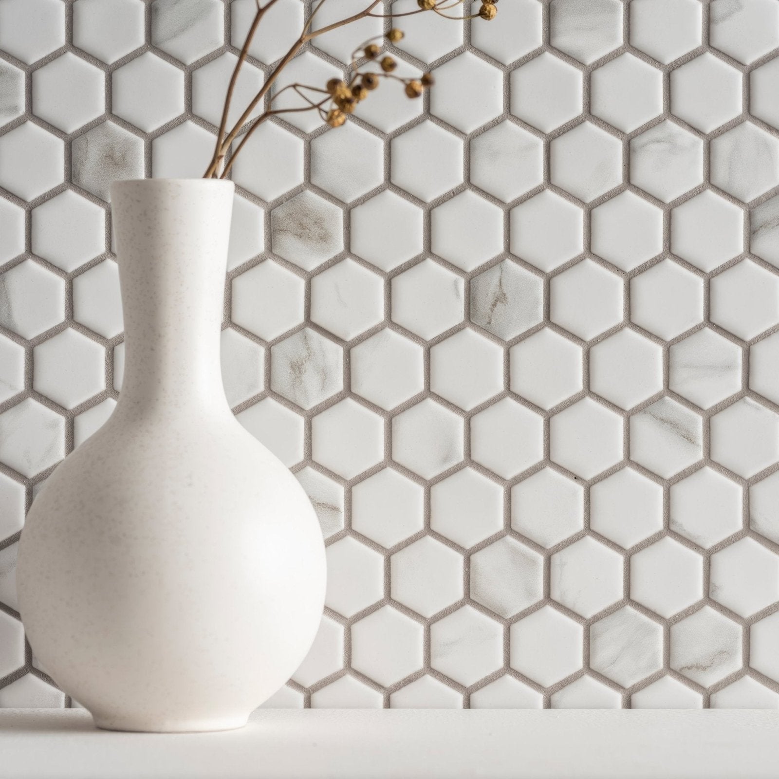 A sleek matte white ceramic vase with a rounded body and slender neck from hexagon matt carrara white collection