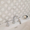 High Society Marble Guggenheim white marble mosaic backsplash with a chrome three-handle tap