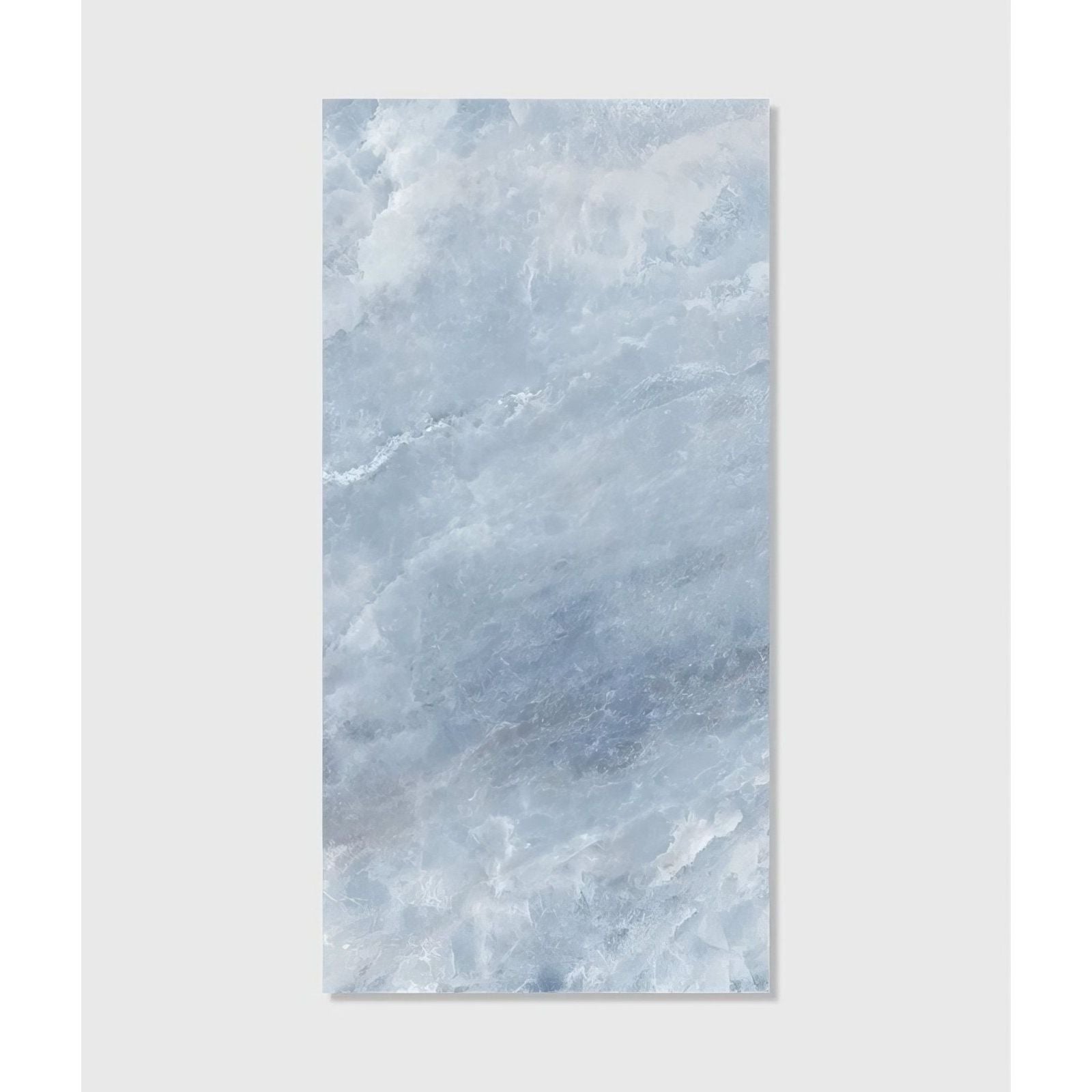 A rectangular slab of himalaya porcelain matt ice marble with light blue and white veins and a polished surface