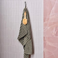 Hollywood Porcelain Rose pink marble-effect tiles with a green and white striped towel