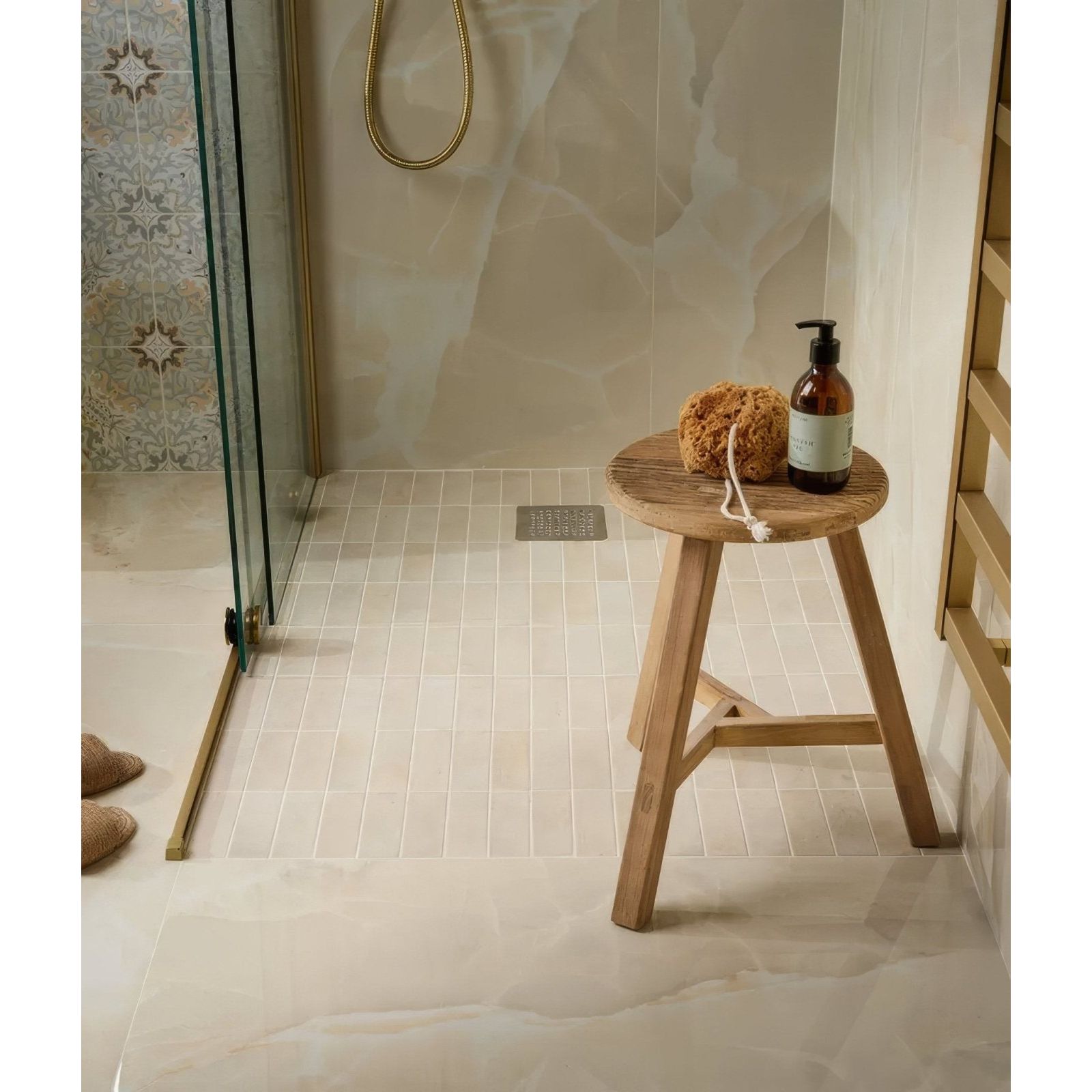 Hollywood Porcelain Sand cream marble-effect tiles with a wooden stool, soap bottle and sponge