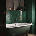 Dark green hexagon gloss ceramic wall tiles with a white clawfoot bathtub in a bathroom setting