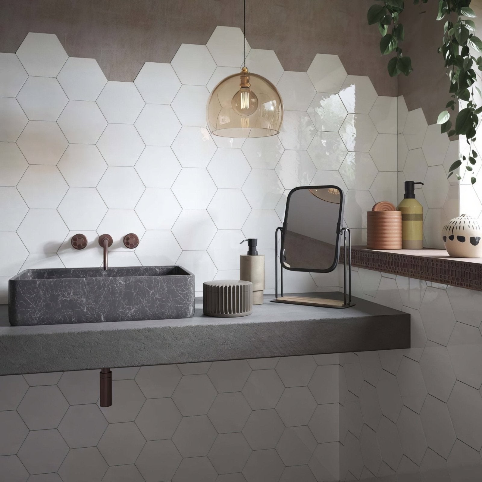 Gray marble rectangular sink with copper faucets installed against hope white hexagon gloss ceramic wall tiles