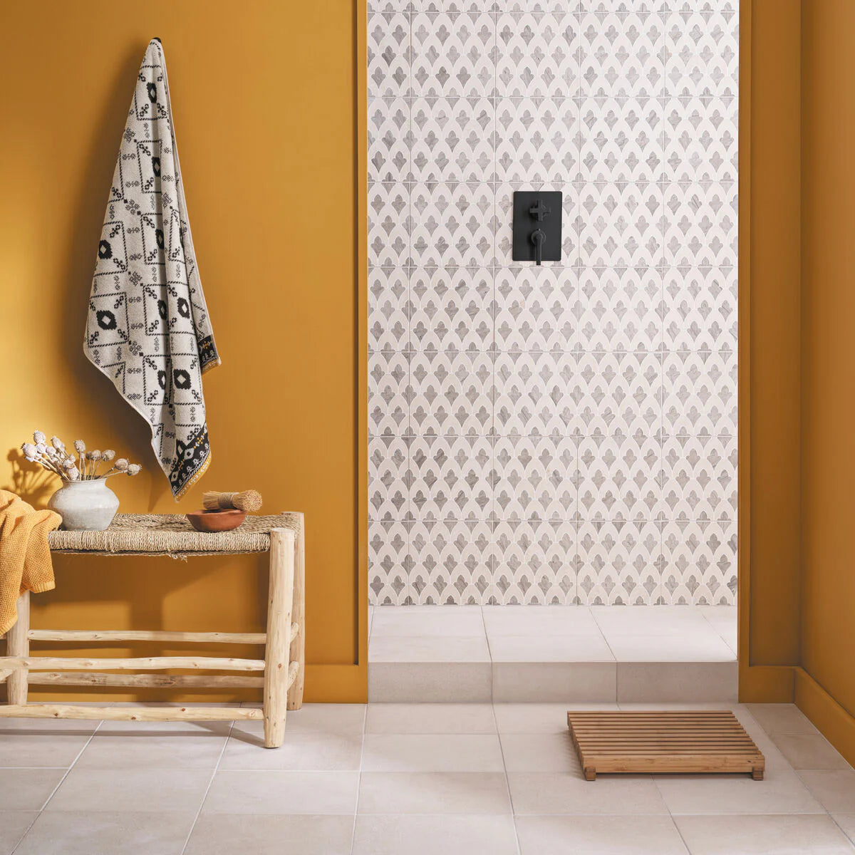 Bathroom interior with a towel hanging on an ironing board, patterned wall, and wooden bench.
