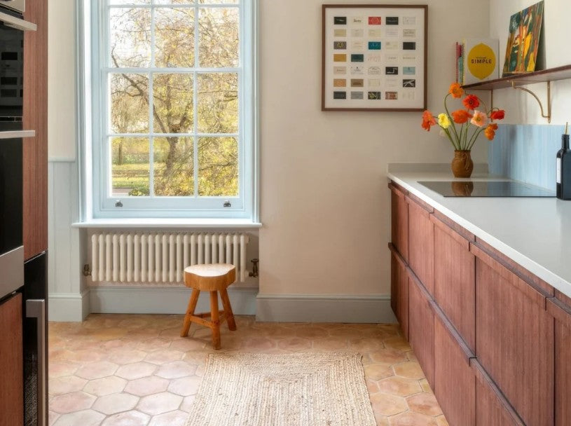 Kitchen with a terracotta hexagon floor beneath a sash window