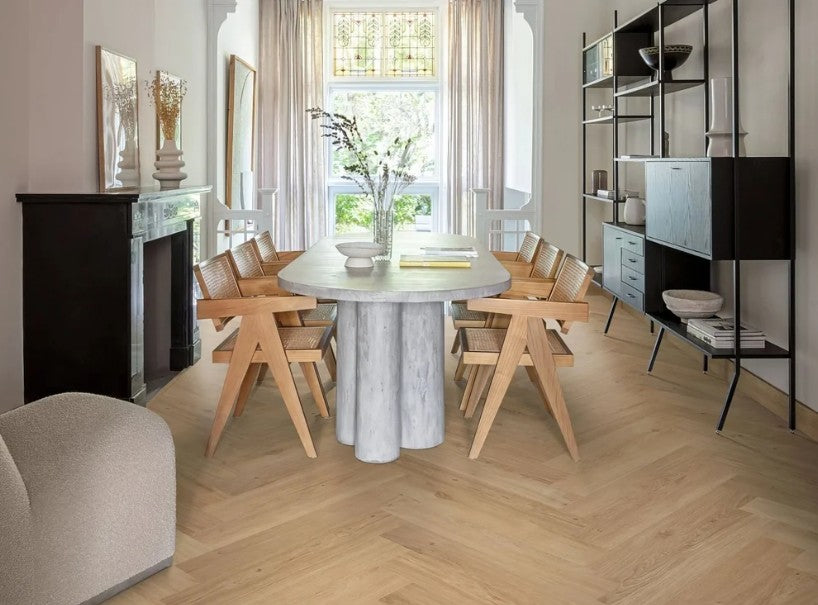 Light oak herringbone flooring in a dining room with a stone table
