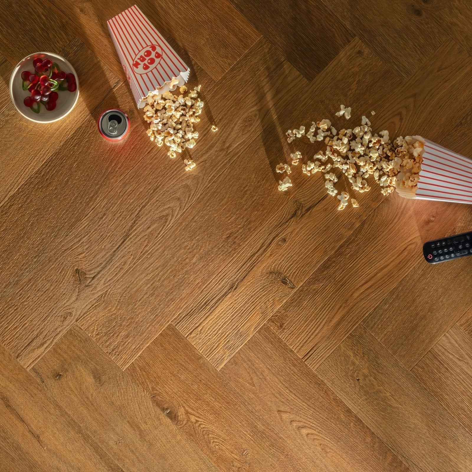 Red and white striped popcorn box with hot pop branding spilling golden kernels on ikura f333 vinyl herringbone floor