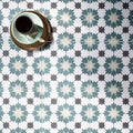 Infusion amparo patterned tile with a teal and white geometric starburst design on a floor surface