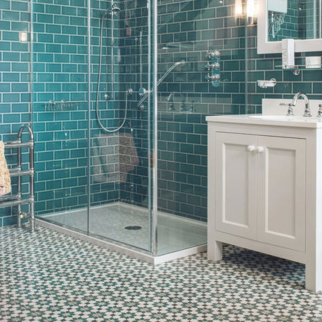 White vanity cabinet with silver hardware and round knobs featuring infusion amparo patterned tile design