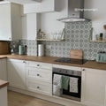 Silver zephyr range hood with curved edges and sleek modern design shown with infusion ornelas patterned tile background