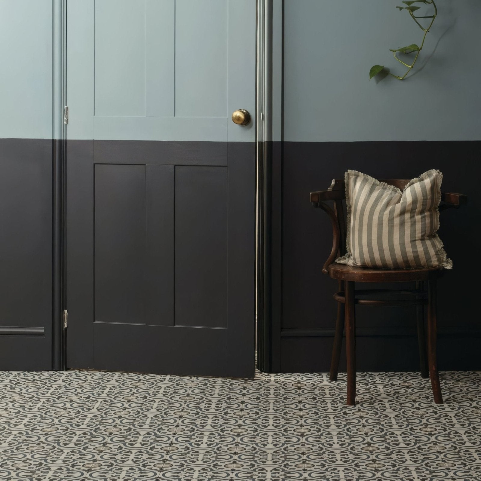 Striped beige and gray pillow with frayed edges on dark wood chair featuring infusion st etienne patterned tile design