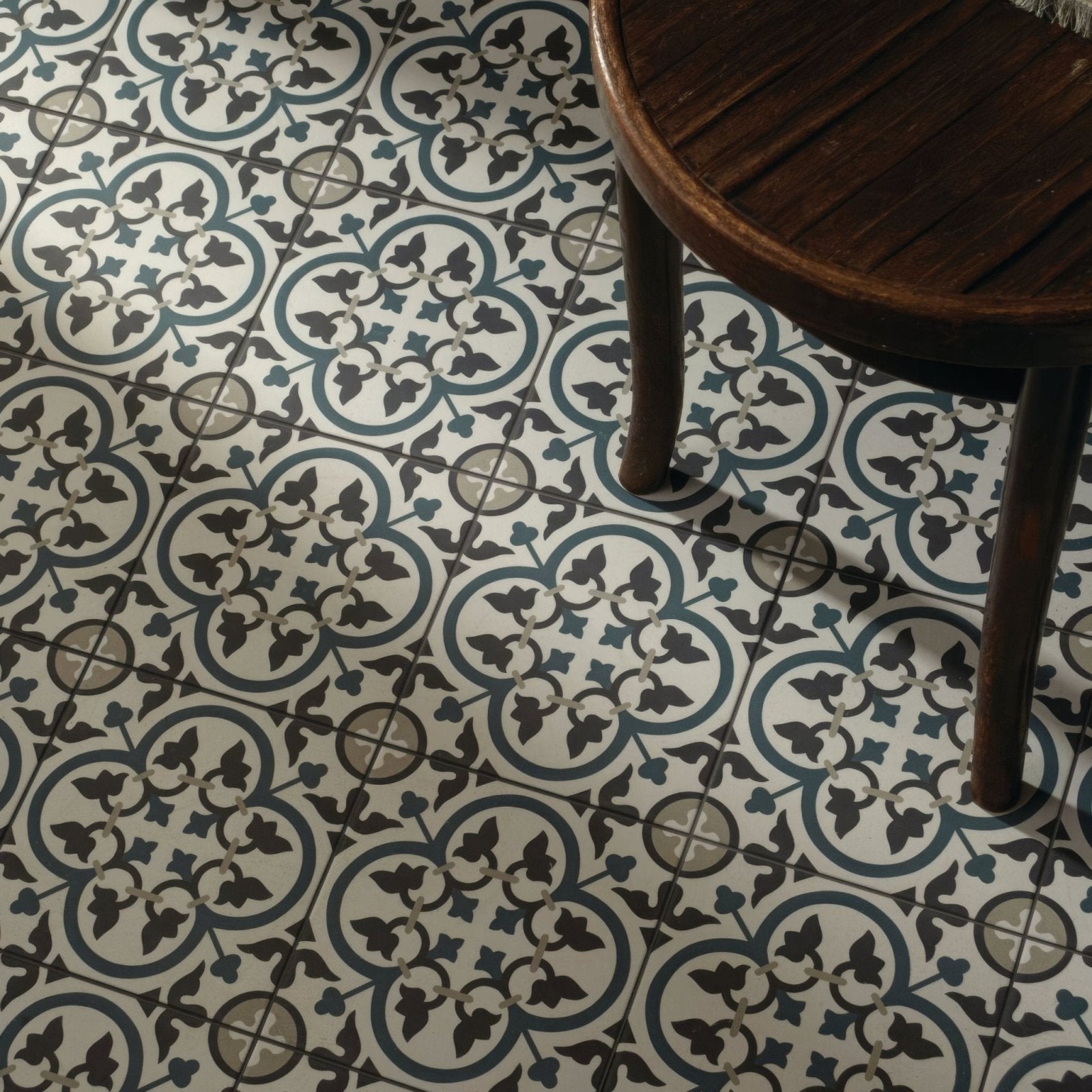 Infusion st etienne patterned ceramic floor tile with repeating quatrefoil design in dark gray teal blue and off-white