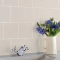 Ivory field tile featuring a white ceramic pitcher holding a bouquet of vibrant blue flowers as decor