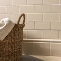 Ivory half tile natural woven wicker laundry basket with a sturdy braided handle for durable storage