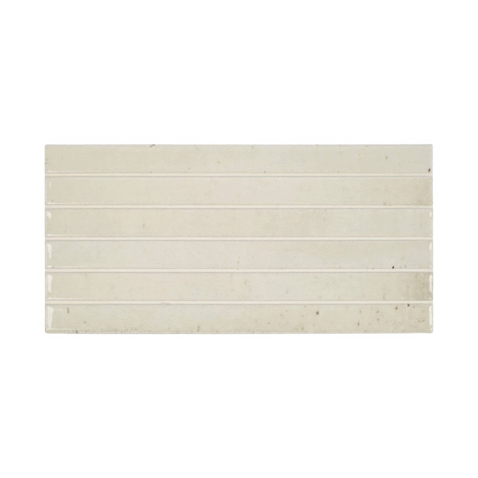 Cream-colored ceramic ixworth bone bar tile with rectangular shape, horizontal grooves, and subtle speckles