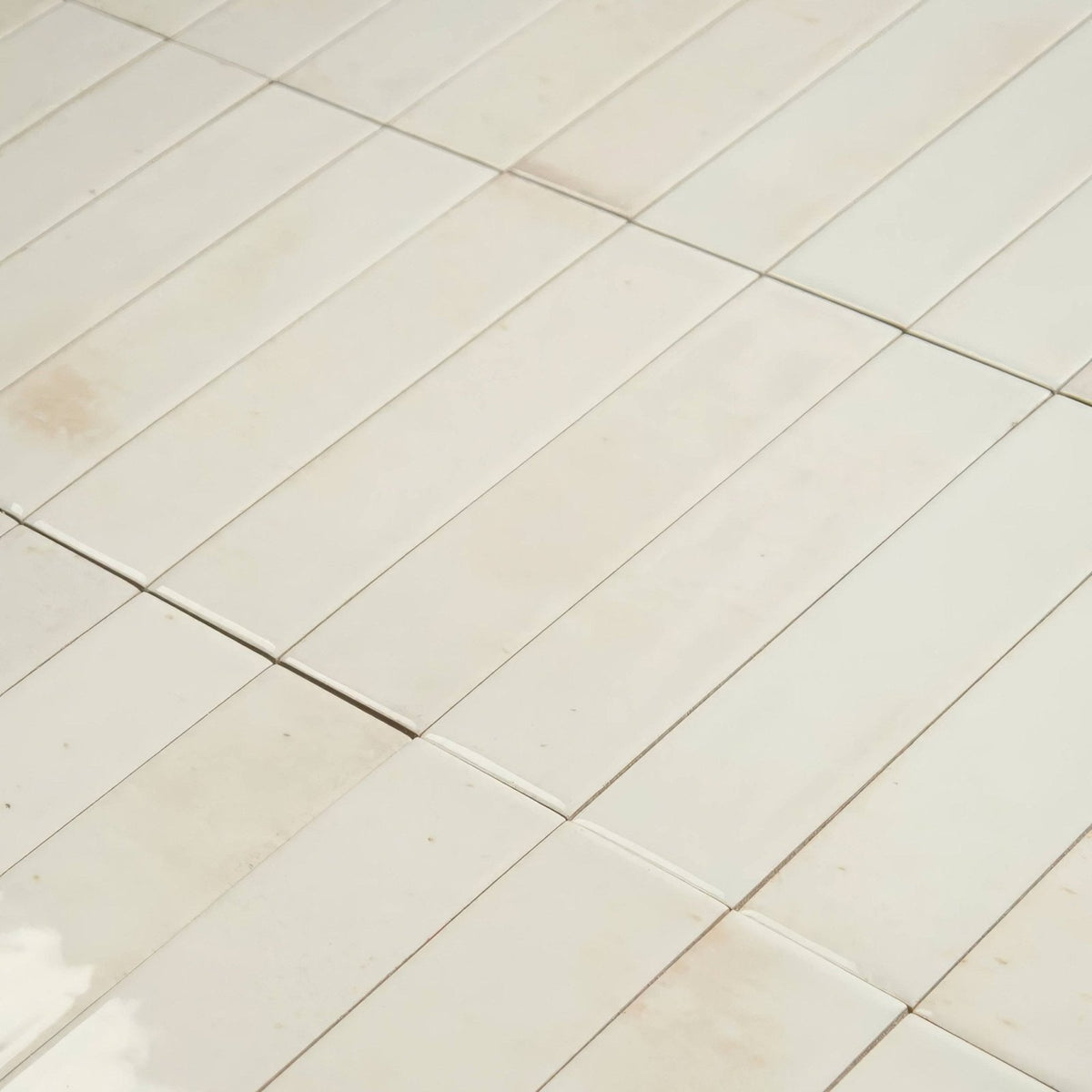 Off-white rectangular ceramic floor tile ixworth bone brick tile with subtle natural variations and thin grout lines