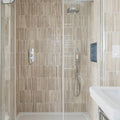 Modern shower enclosure featuring ixworth ivory bar tile with sleek vertically striped beige ceramic tiles and chrome rainhead