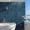 Deep blue matte finish ixworth navy brick tile rectangular wall tiles behind a white freestanding bathtub
