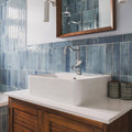 White rectangular ceramic sink with polished chrome faucet on wooden vanity against ixworth sky brick tile walls