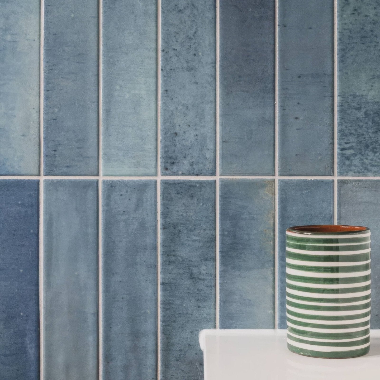 Green and white striped ceramic cylindrical container with brown interior for ixworth sky brick tile use