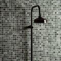 Jade 2.3 Venetian Stone Mosaic green marble mosaic with a black matte showerhead