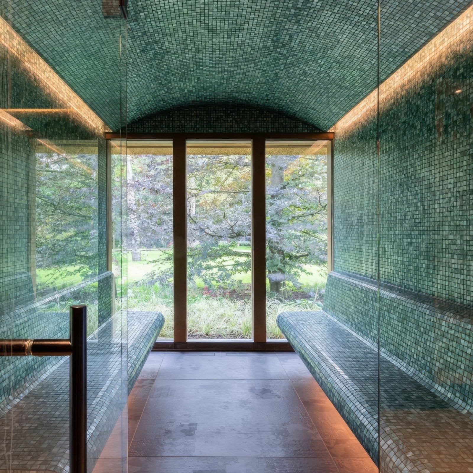 Green mosaic-tiled jade 25mm square sauna with built-in benches and a large window for relaxing use