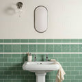 A white ceramic jade breeze half tile pedestal sink with sleek minimalist design and chrome faucets