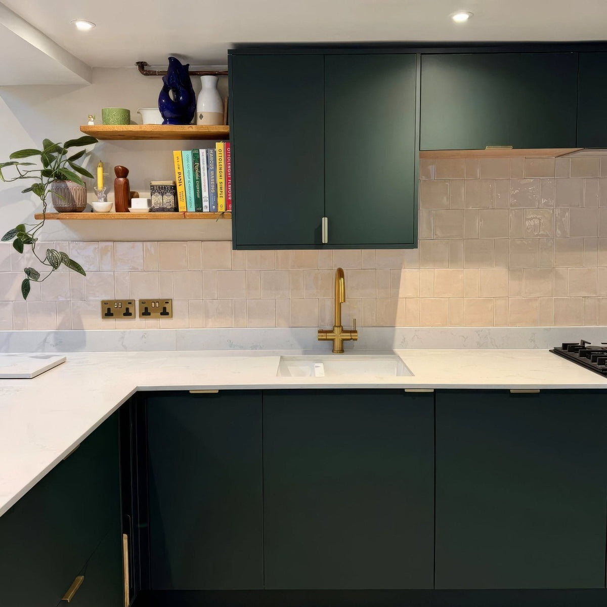 Gold-toned kitchen faucet with modern minimalist design paired with jaipur old ochre rectangle glazed tile background