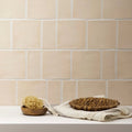Beige ceramic jaipur old ochre square glazed subway tile with subtle texture and white grout for wall use