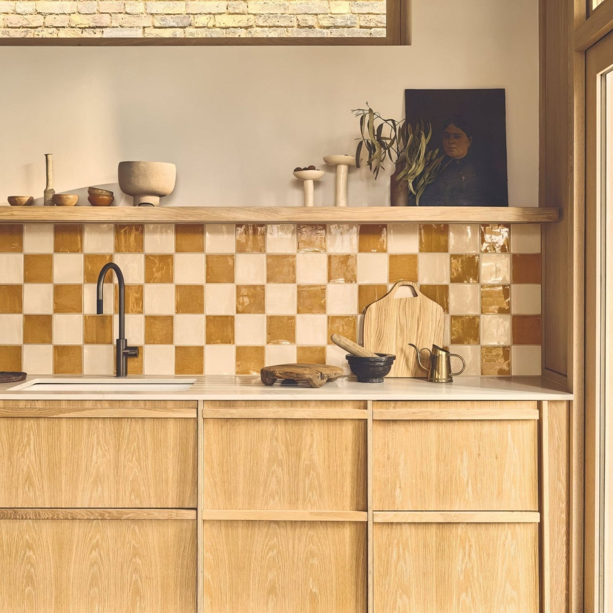 A rustic wooden cutting board with a natural handcrafted finish and visible grain displayed on a jaipur old ochre square glazed tile