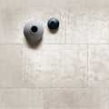 Two minimalist ceramic vases in matte gray and dark teal on textured beige tile in jerusalem silver 90 x 60cm