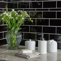 Jet Black Half Tile wall with a ribbed glass vase of white flowers standing against it