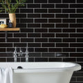 Jet Black Large Brick tiling laid in brick bond with white grout, the joints drawing a bright grid across the wall